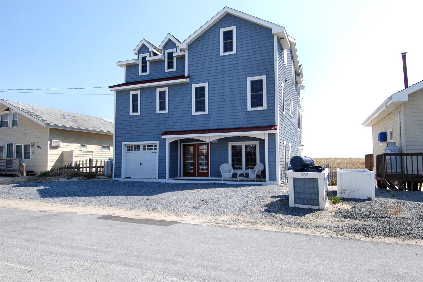 Charming blue coastal property with private parking and easy beach access, nestled in a quiet residential neighborhood near the shore.