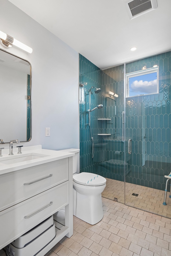 Step into your private spa-like retreat, where stunning teal tile and natural light create a calming oasis. The spacious walk-in shower invites you to unwind after a day of exploring.