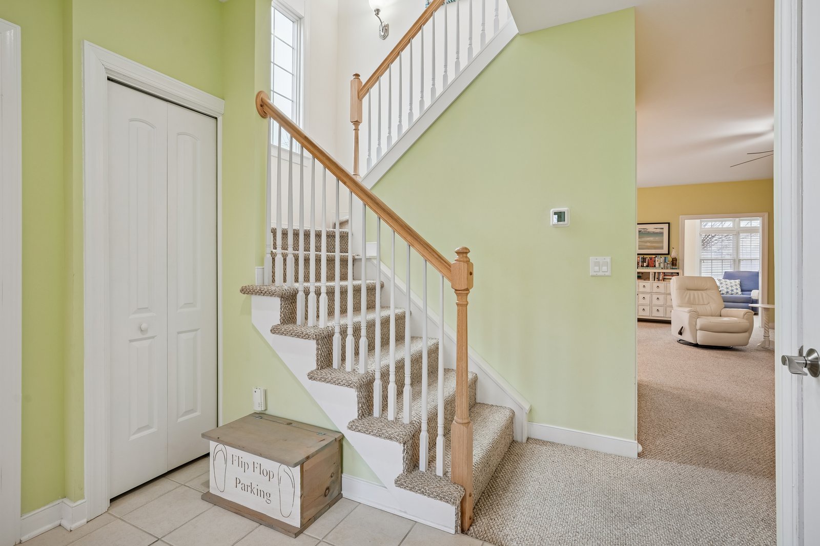 Step into your welcoming entryway with elegant carpeted stairs and bright, airy spaces flowing into the comfortable living area.