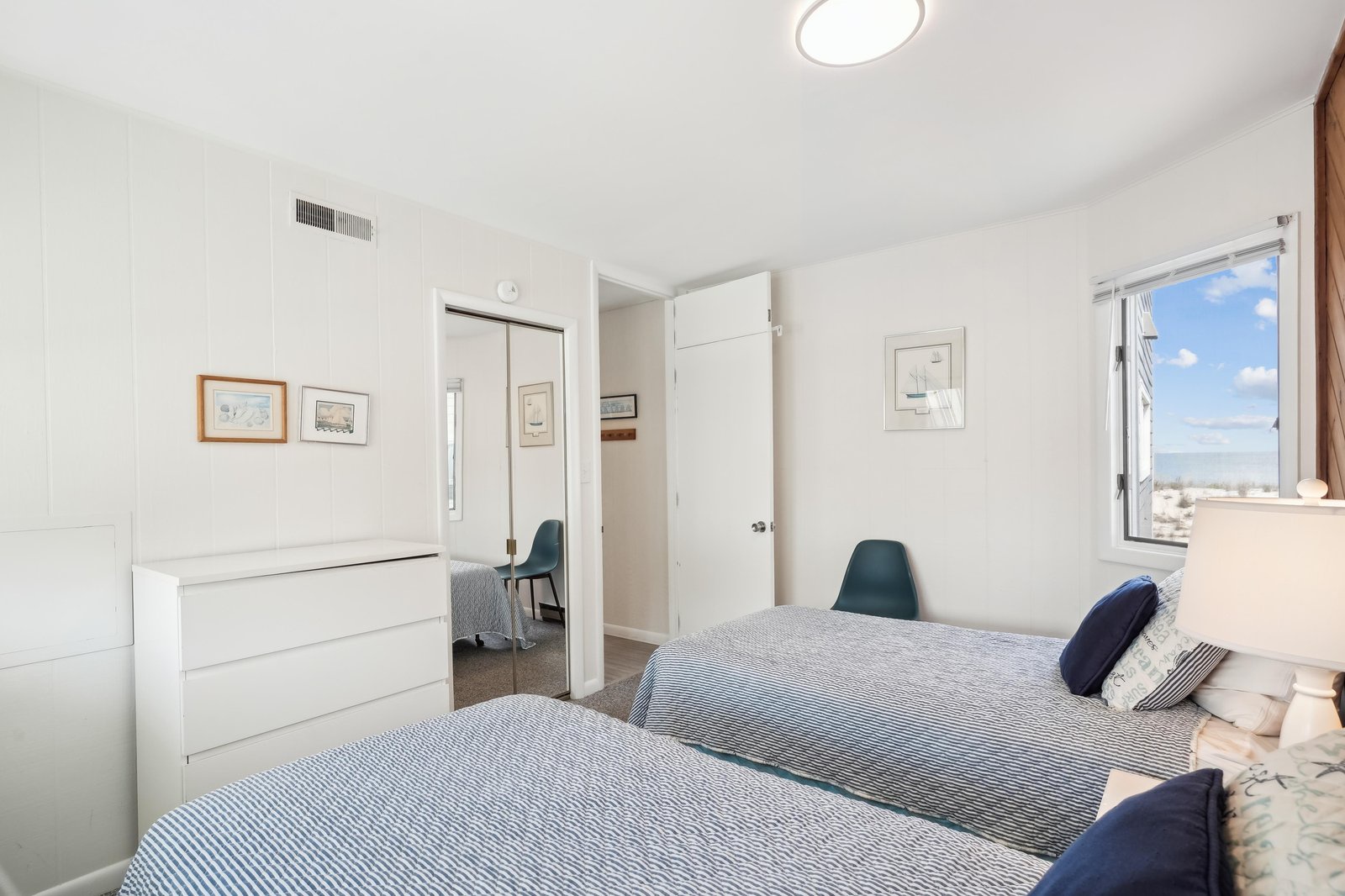 Light pours into your bright, peaceful bedroom, where two comfortable beds await and mountain scenery frames your morning view through the large window.