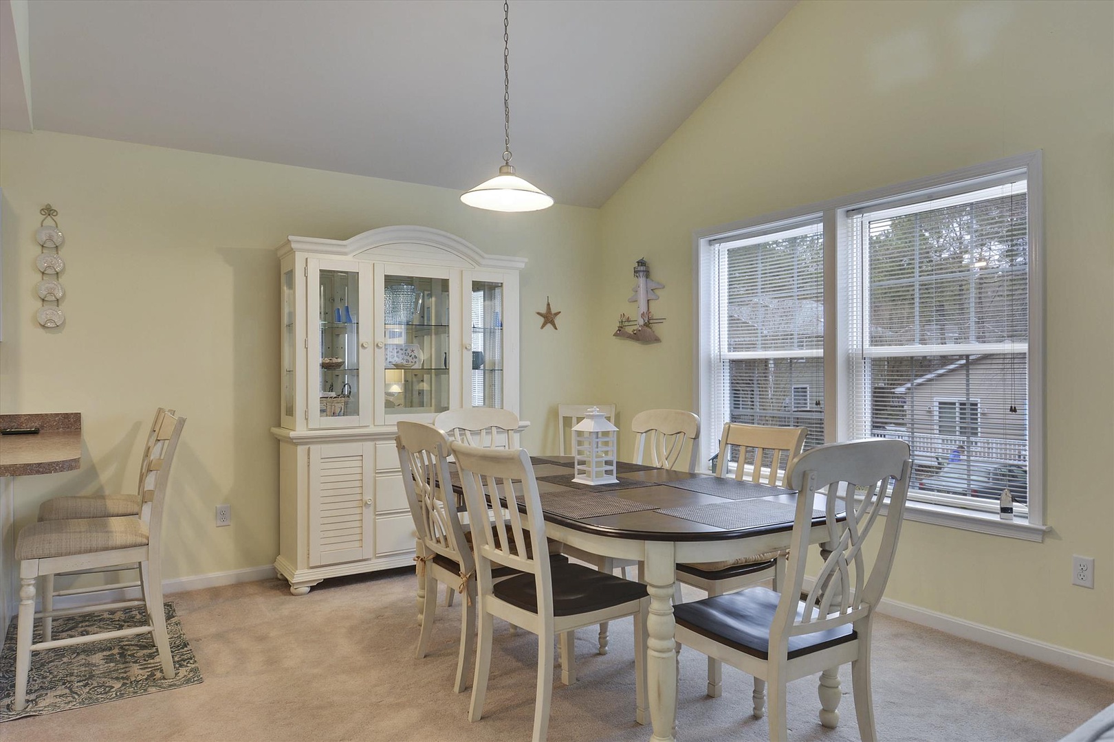 Gather around this inviting dining table for meals together, with plenty of natural light streaming in and a charming hutch to display your favorite dishes.