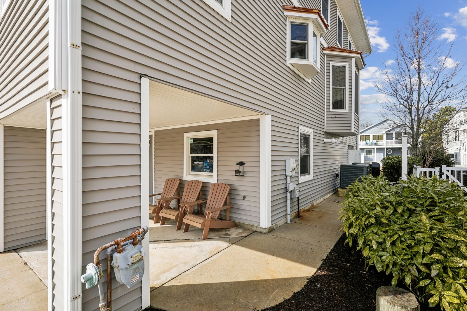 Cozy covered patio with comfortable wooden chairs where you can relax and unwind after exploring the neighborhood.