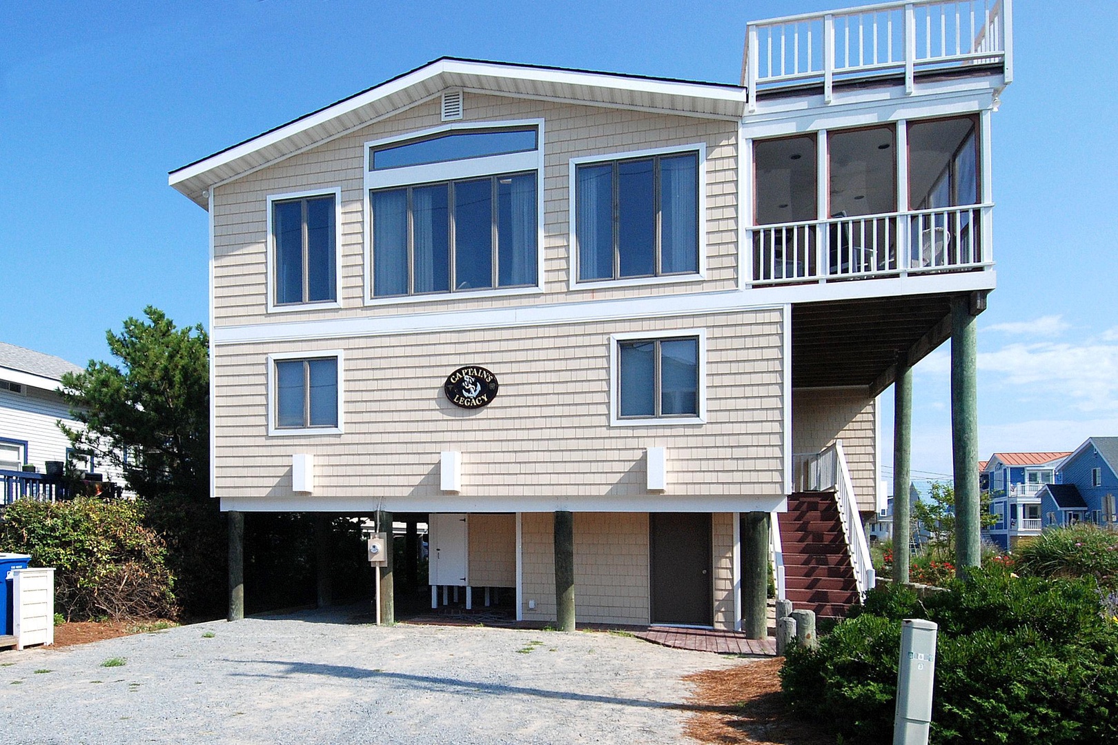 Beachside property featuring coastal architecture with spacious balconies and covered parking, nestled in a quiet neighborhood near the shore.
