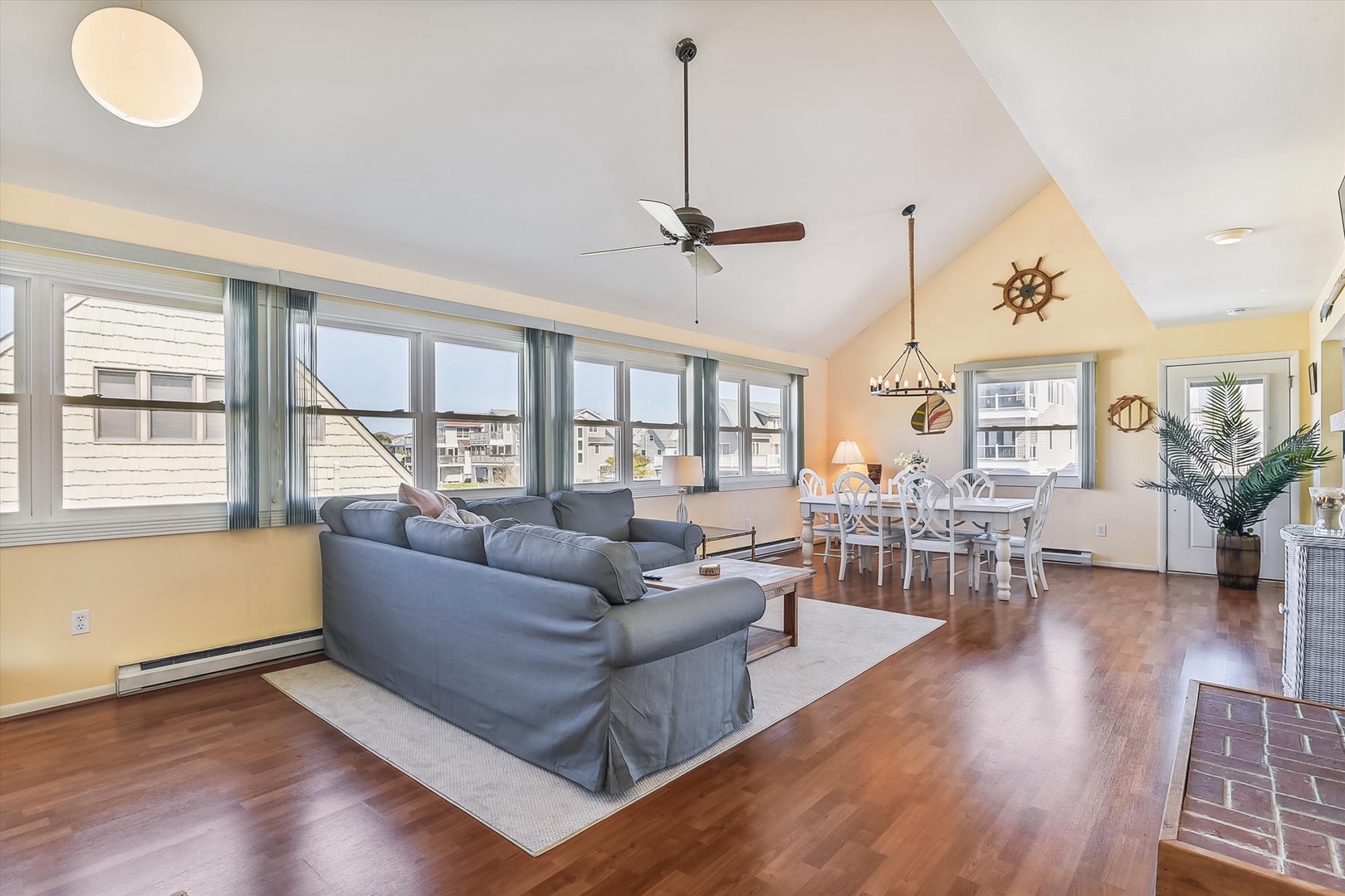 Picture yourself relaxing in this bright, open-concept living space with high vaulted ceilings, coastal nautical touches, and warm hardwood floors that flow seamlessly from the cozy lounge to your dining area.