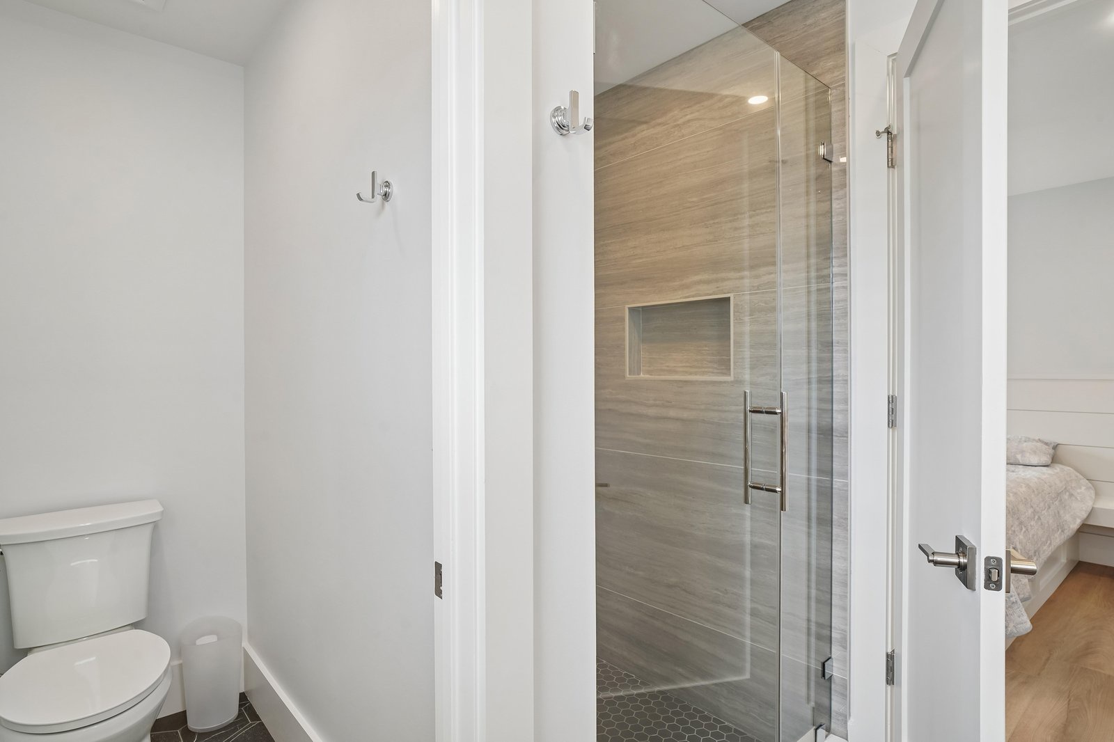 Rinse away the day in your beautifully tiled walk-in shower, complete with a recessed niche for your essentials. Clean lines and modern finishes make this bathroom a serene retreat.