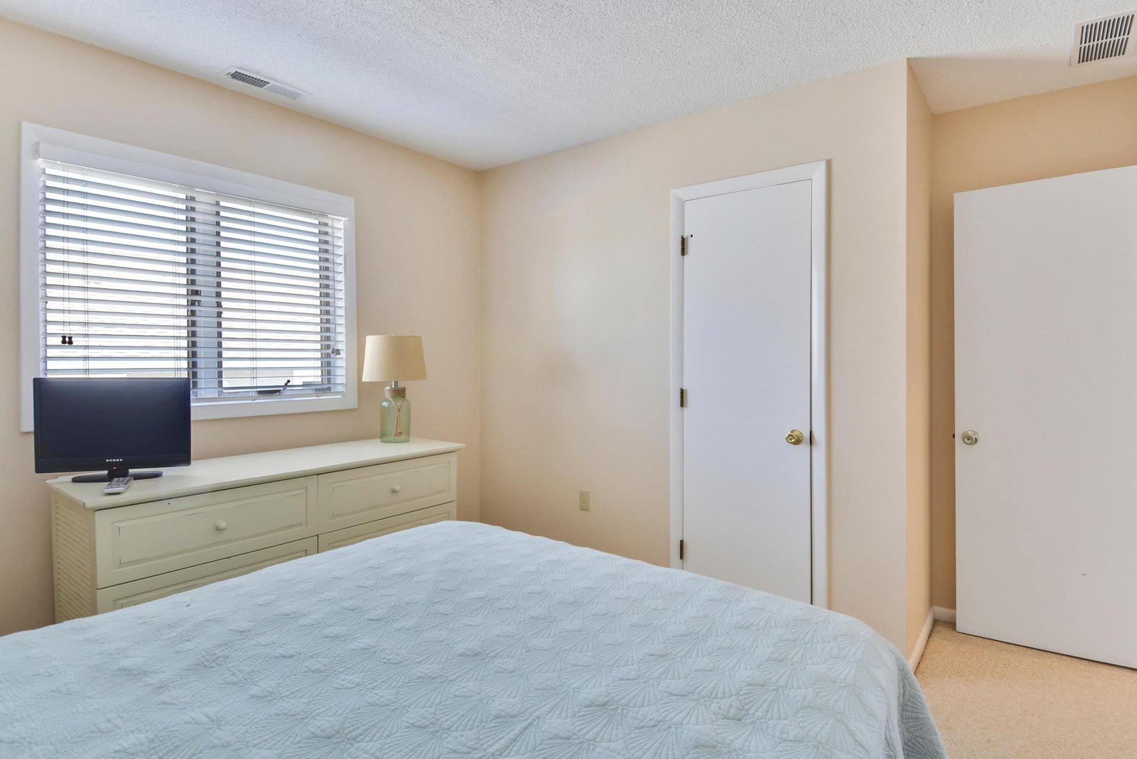 Relax in your peaceful bedroom, featuring soft natural light from the window, a cozy bed with fresh linens, and plenty of storage to make you feel right at home.