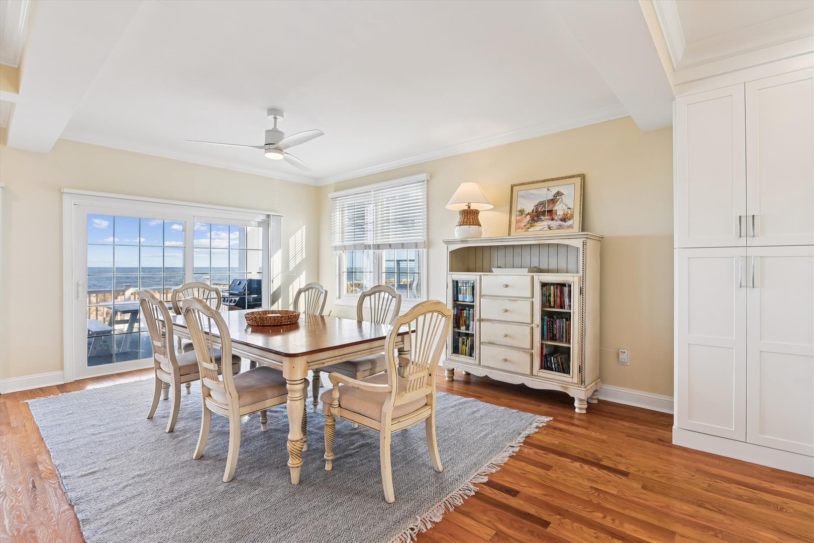 Gather around this charming dining table with coastal views stretching beyond the glass doors, where your meals are framed by ocean breezes and warm natural light.
