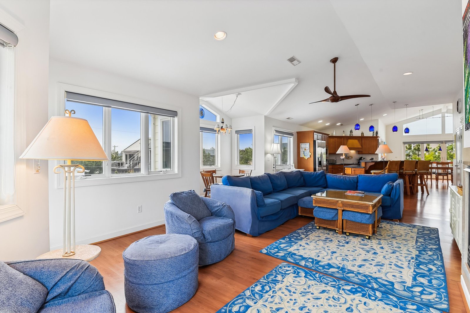 Sink into the plush blue sofas and let your eyes wander across the open layout—bright, airy, and effortlessly inviting, with natural light streaming in and room to unwind or gather.