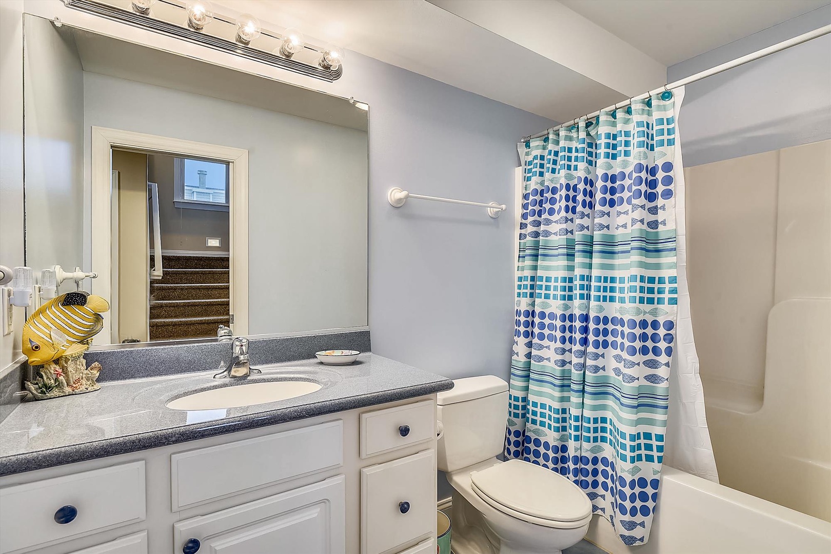 You'll love freshening up in this bright bathroom with its cheerful blue accents, modern fixtures, and plenty of vanity space for all your essentials.