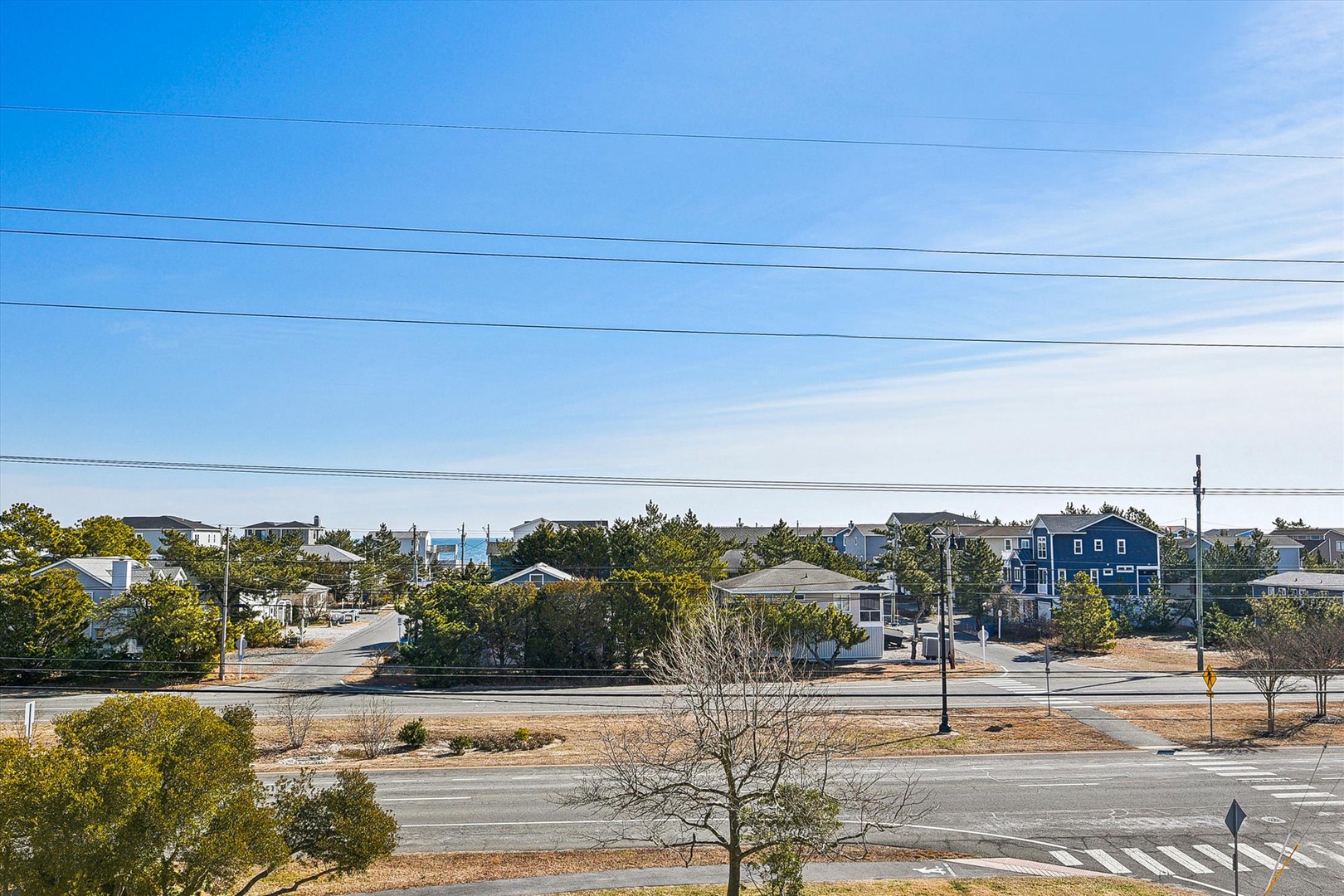 Peaceful coastal community with charming homes nestled among mature trees and quiet streets under clear blue skies.