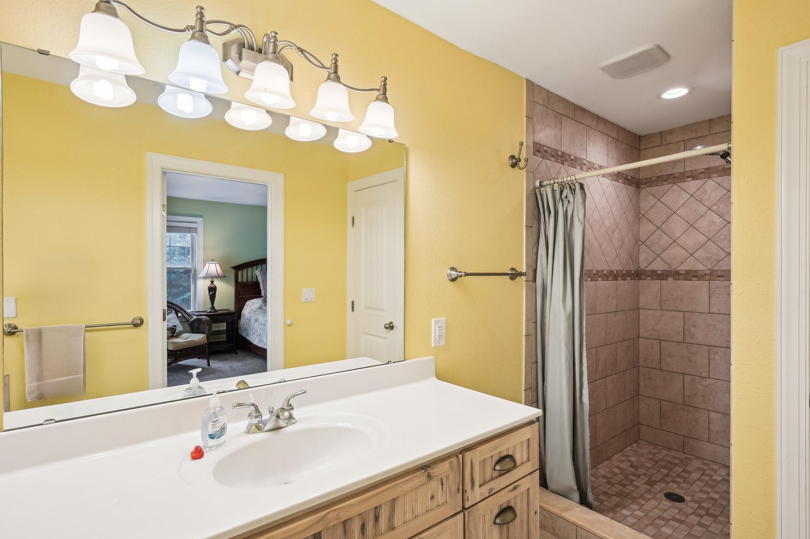 Step into your bright, welcoming bathroom with a spacious walk-in shower and warm tile finishes that make mornings feel just a little more luxurious.