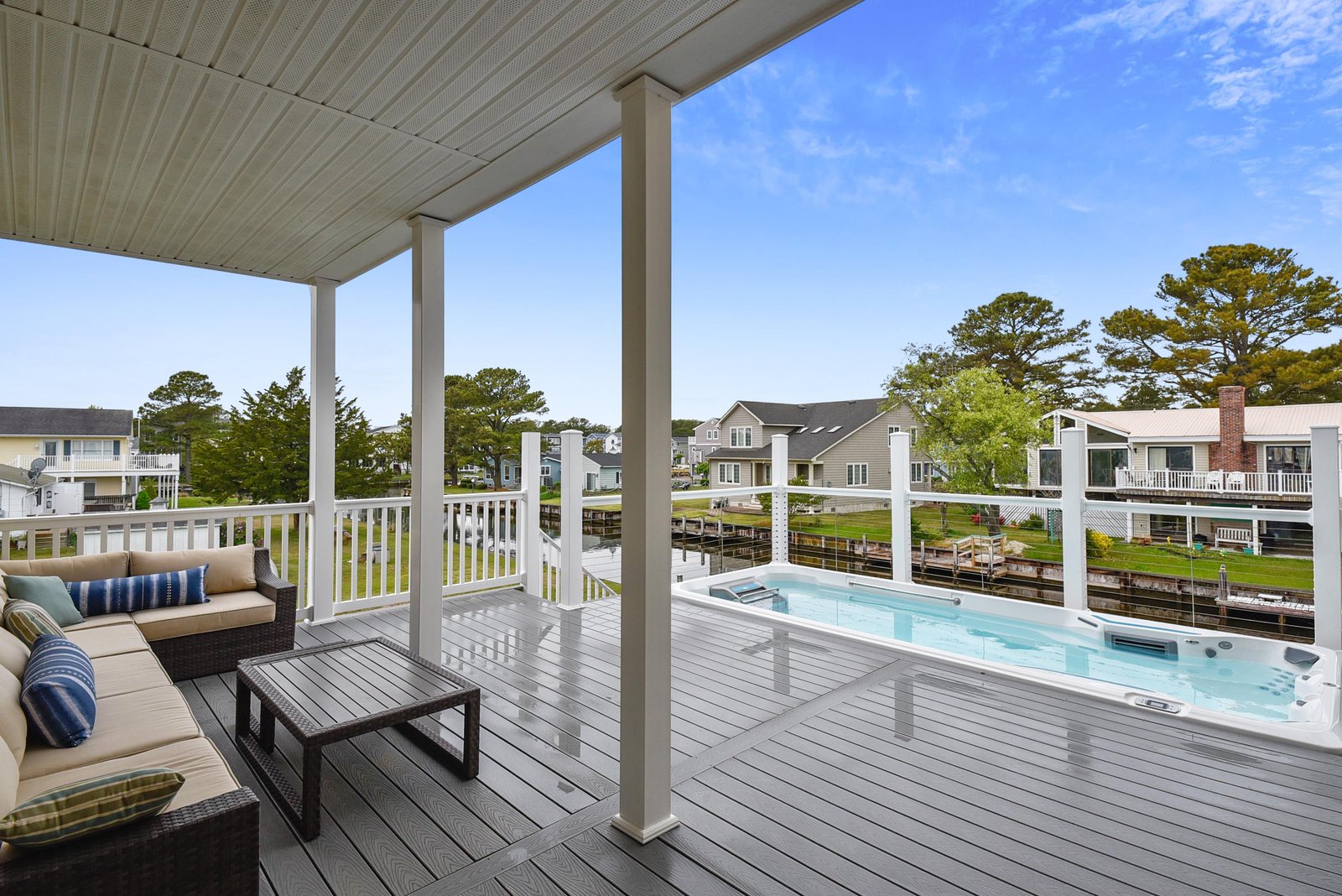 Unwind on your private deck with comfortable seating and a sparkling hot tub overlooking peaceful waterfront surroundings—perfect for soaking under open skies.