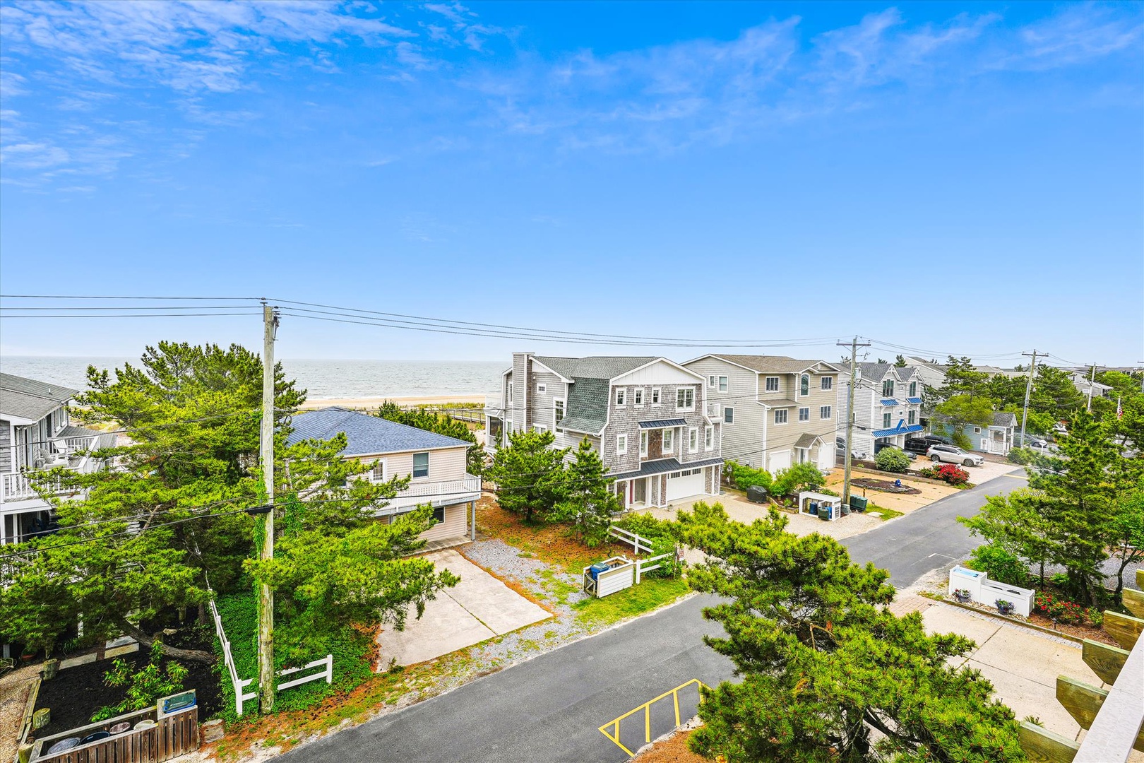 Elevated view of the property's coastal neighborhood setting, surrounded by lush greenery and just moments from the beach. This peaceful residential area offers easy access to local attractions.