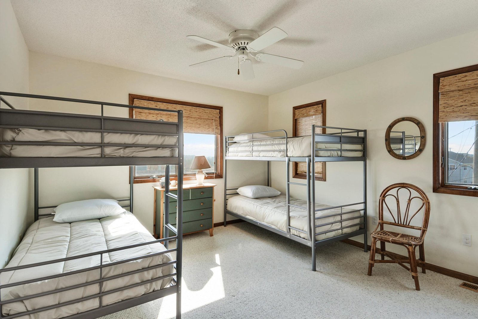 This cozy bunk room sleeps a crowd with two sturdy bunk beds, perfect for families or groups traveling together. Natural light fills the space through large windows, while a ceiling fan keeps you comfortable.