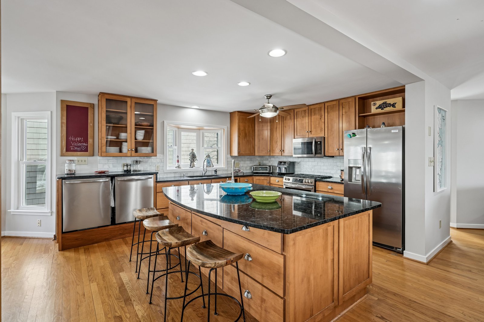 Your fully equipped kitchen features warm wood cabinetry, granite countertops, stainless appliances, and a spacious island with seating—perfect for preparing meals and gathering with loved ones.