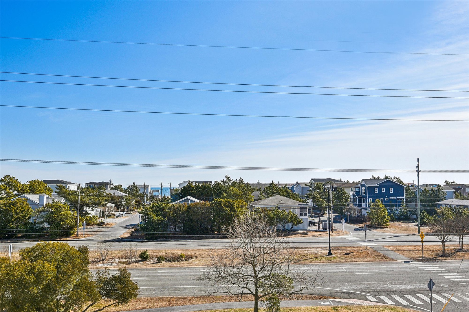 A coastal neighborhood with beach homes nestled among mature trees, offering a peaceful residential setting near the shore.