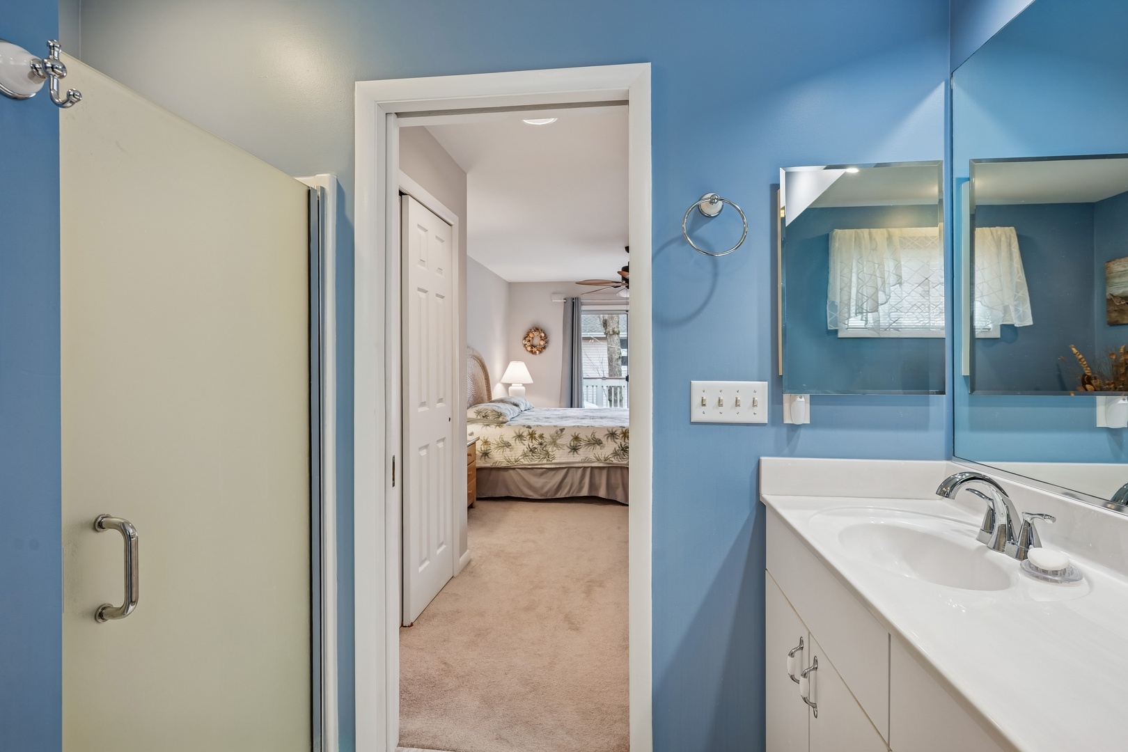 Your bright blue bathroom connects to a cozy bedroom, creating a peaceful retreat with fresh towels and modern amenities.