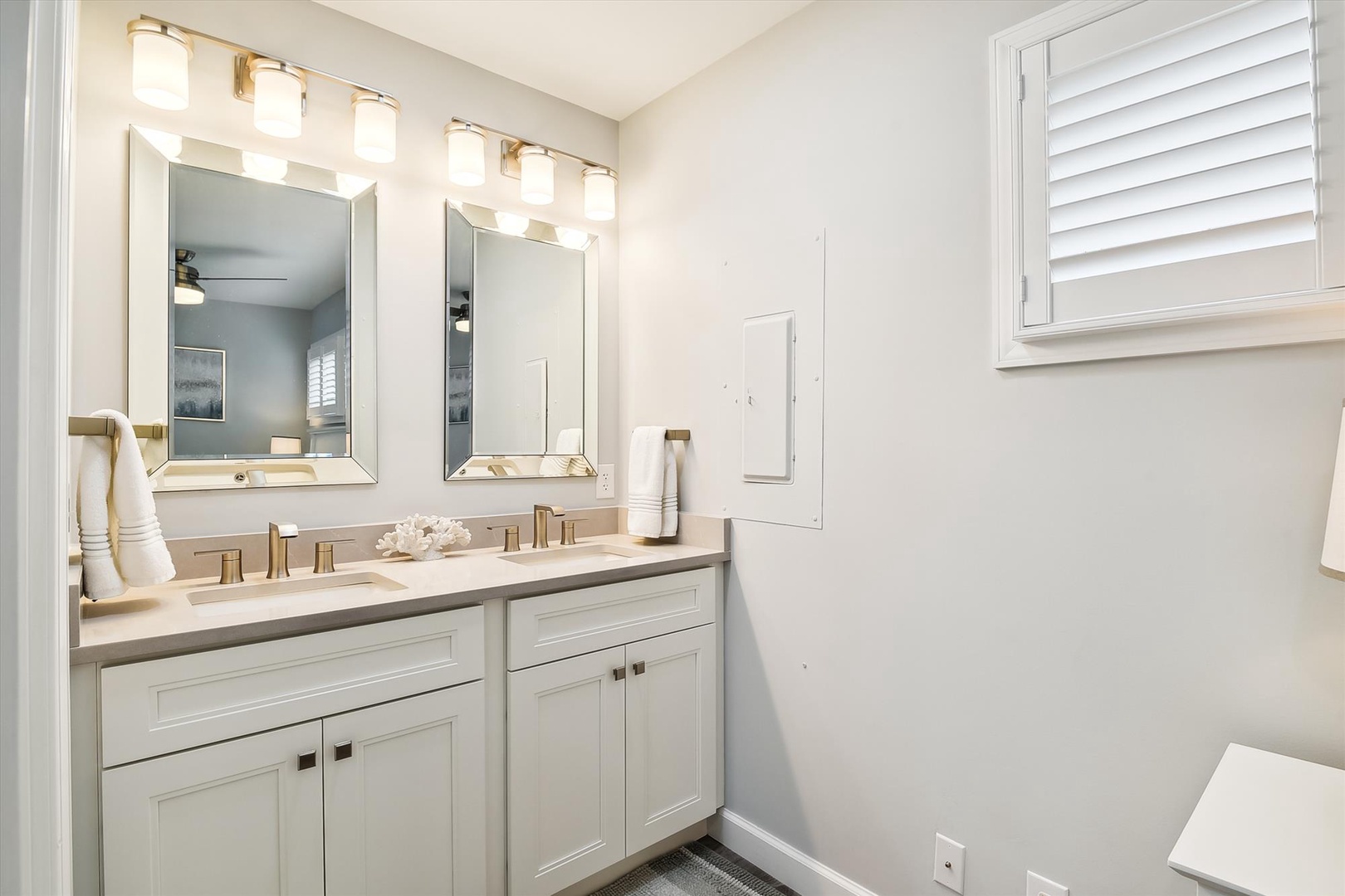Step into your bright, modern bathroom featuring dual vanities, elegant lighting, and fresh white cabinetry—perfect for your morning routine.