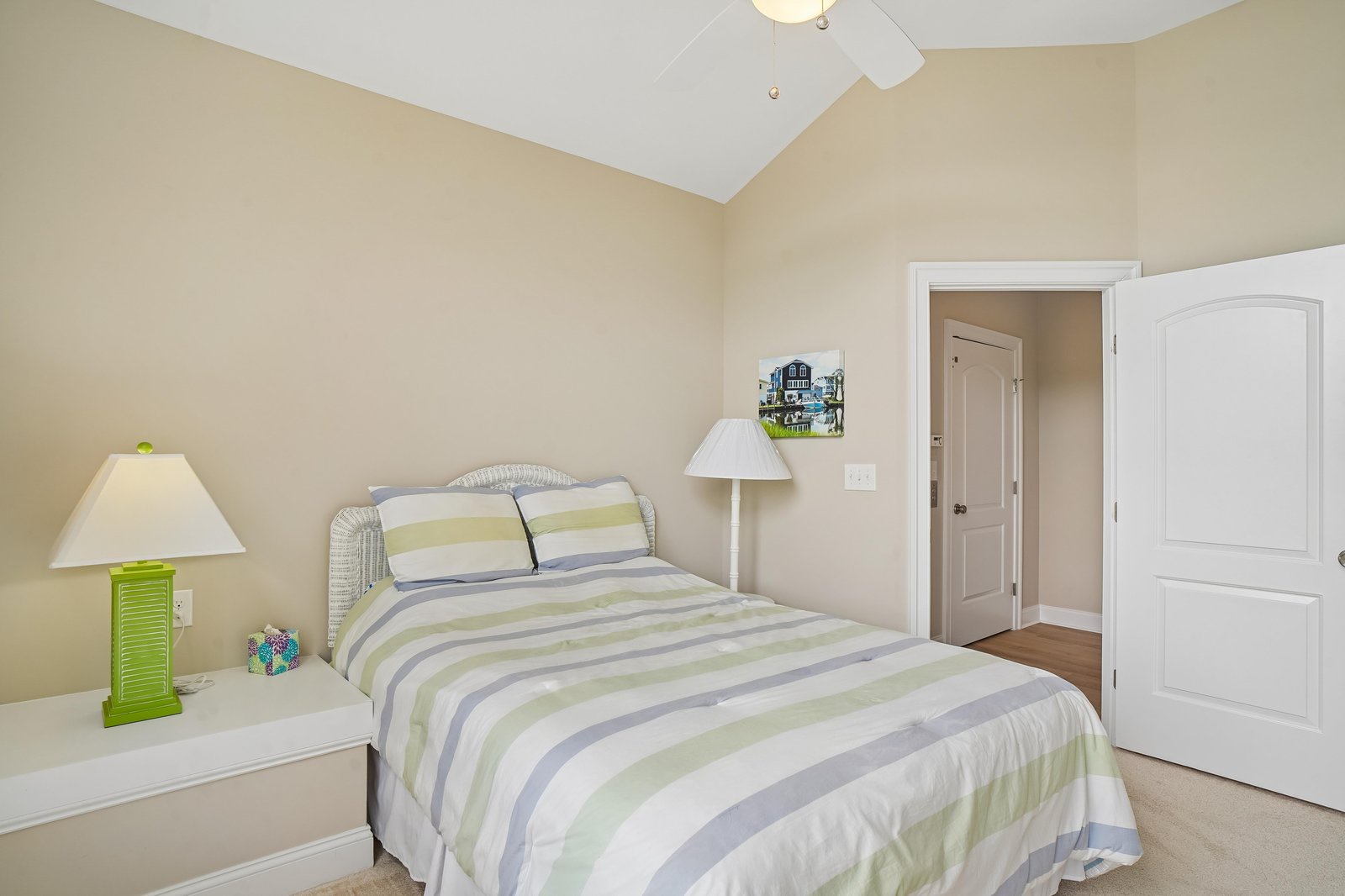 Unwind in your light-filled bedroom with soaring vaulted ceilings and a plush bed dressed in calming coastal stripes, creating the perfect space to recharge after a day of adventure.