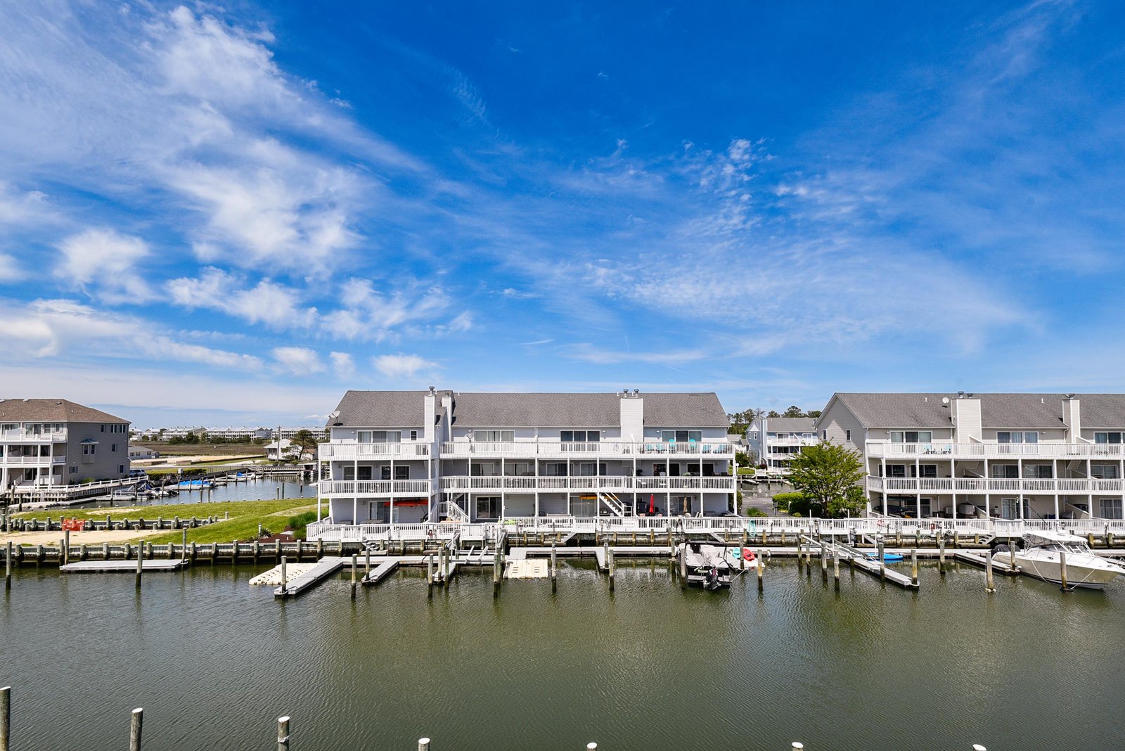 Waterfront vacation condos feature private boat docks along a peaceful canal, perfect for a coastal getaway.