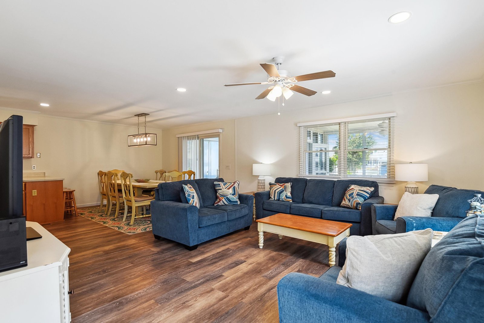 Gather everyone in this spacious living area where comfortable seating, warm wood floors, and coastal accents create the perfect spot for your group to relax together after a day of exploring.