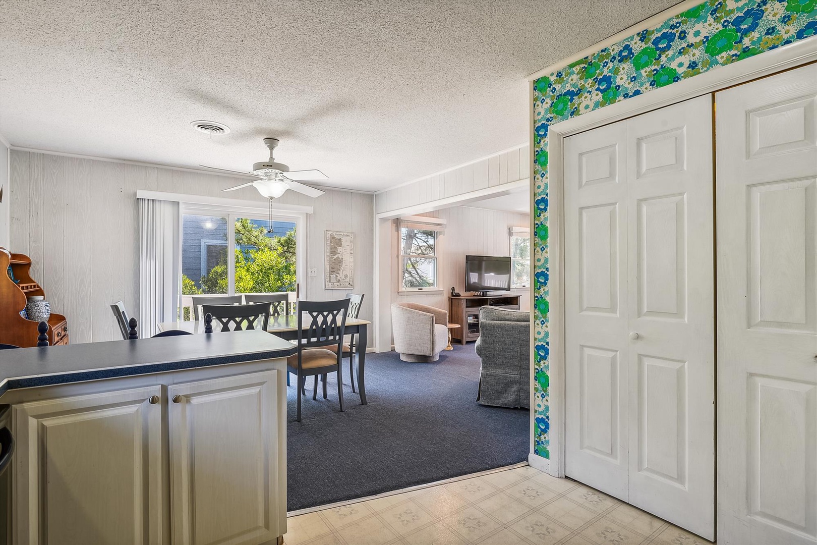 Step into your spacious open-plan retreat, where the bright dining and living areas flow seamlessly together. Natural light pours through large windows, highlighting cozy furnishings and a homey, welcoming atmosphere for your stay.