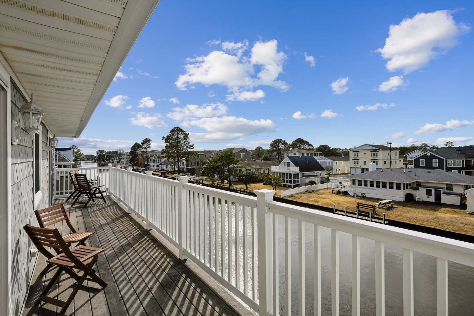Spacious balcony with comfortable seating overlooking the charming coastal neighborhood below.