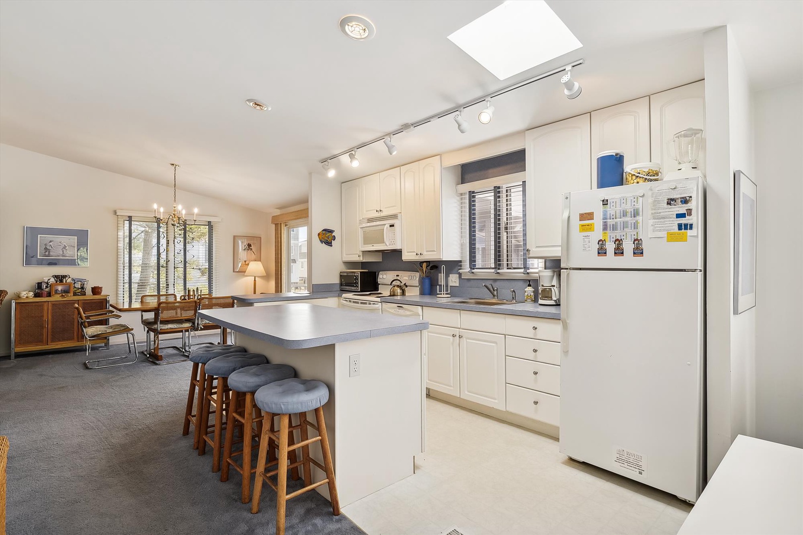 Gather around the spacious island in your fully-equipped kitchen, where bright natural light and modern amenities make cooking feel effortless. Three cozy stools invite conversation while you prepare meals together.