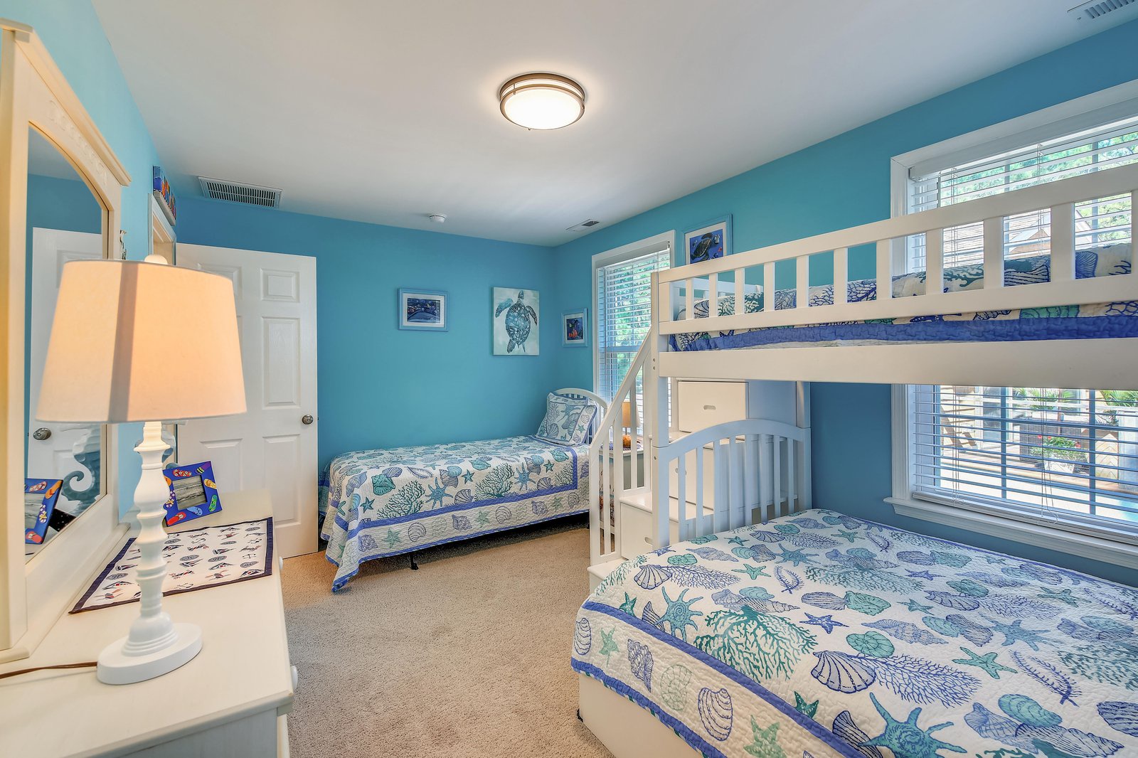 Drift off in this coastal-themed bedroom where ocean-inspired touches and cheerful blue walls welcome you to your seaside escape. Perfect for families, everyone has their own cozy spot.