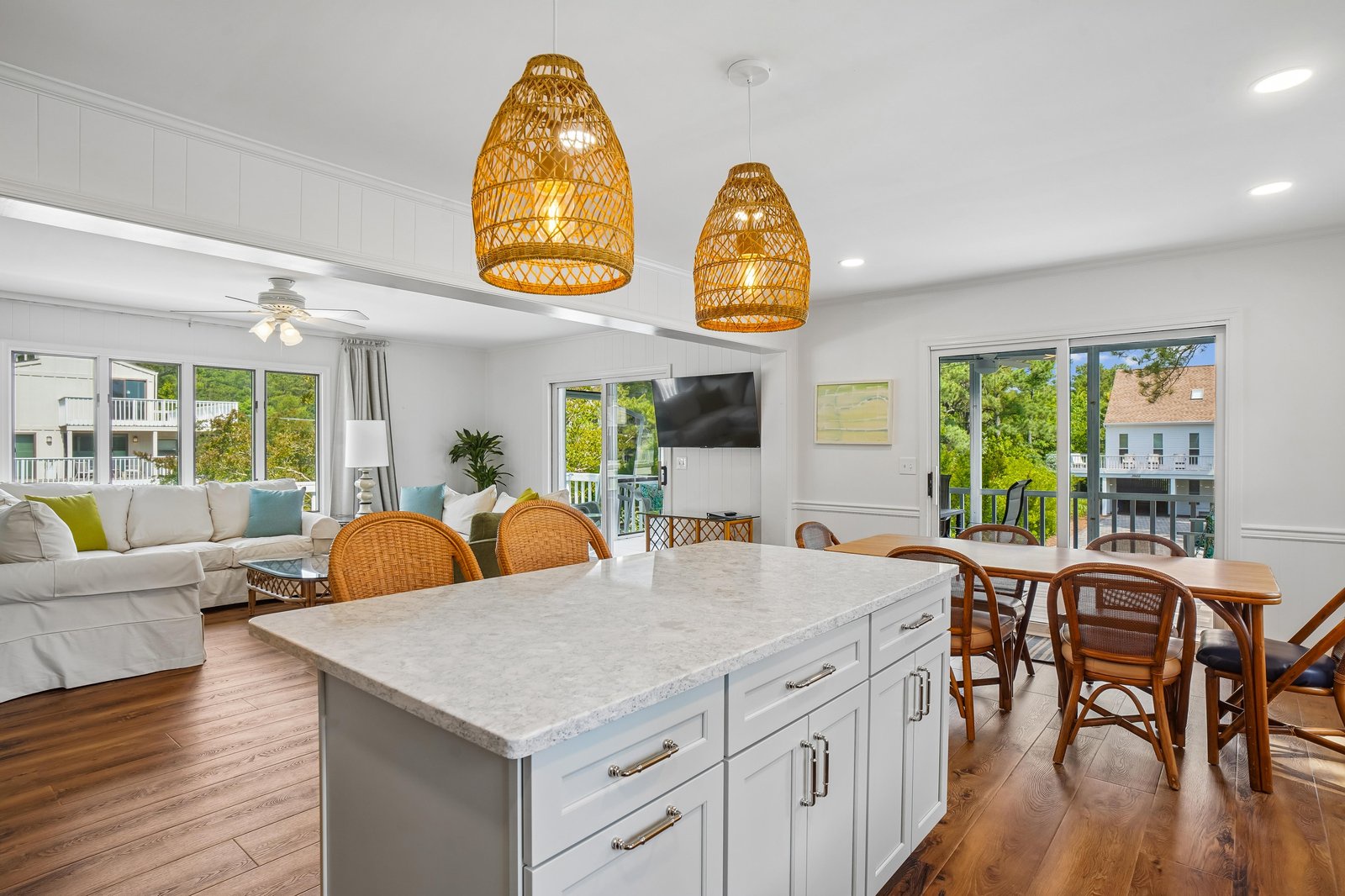 Gather around your open kitchen island with coastal pendant lighting overhead. Relax in the bright living area with views of lush greenery from every window.