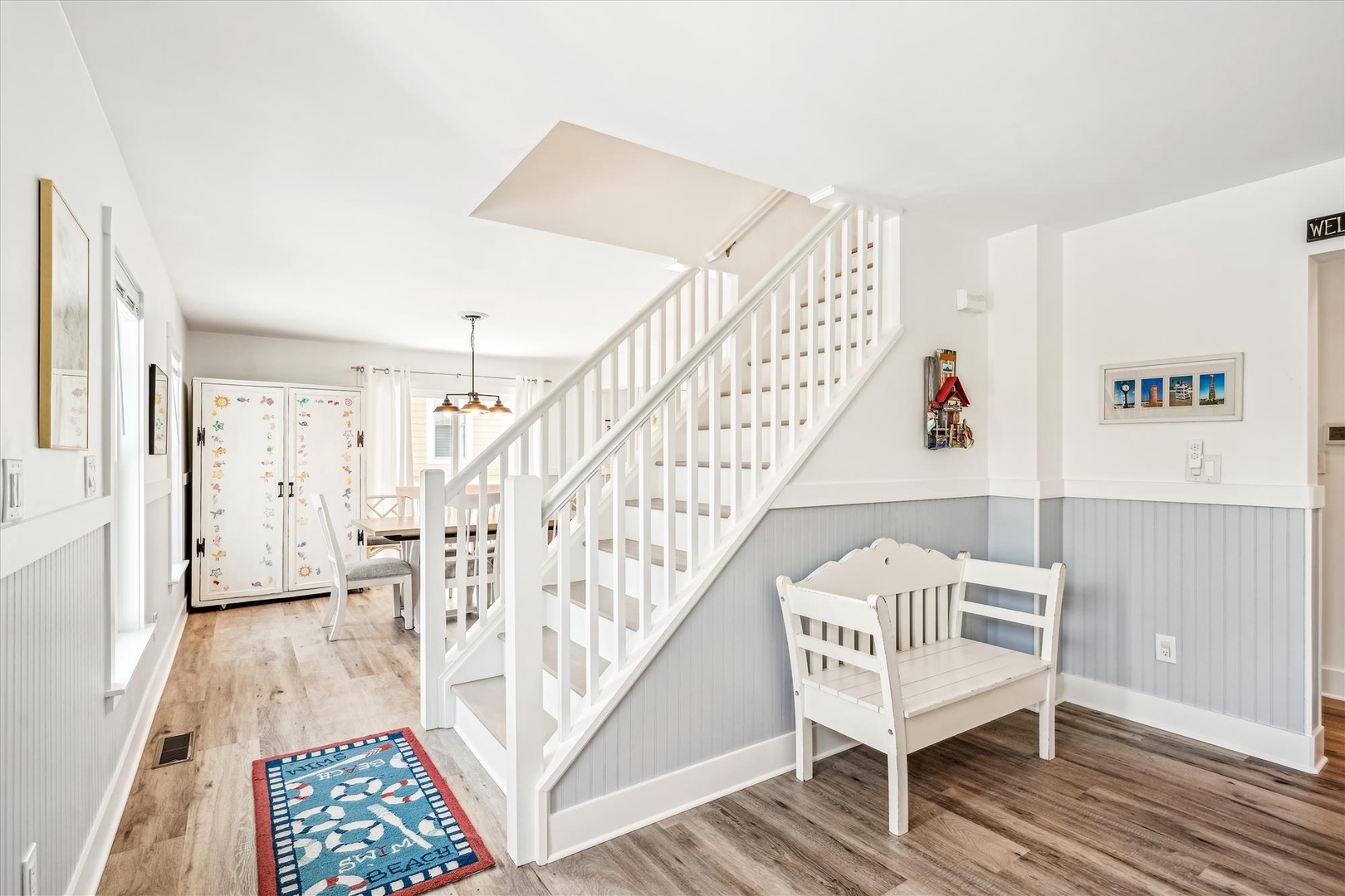 Your charming coastal retreat welcomes you with nautical touches and a cozy reading nook beneath the staircase.