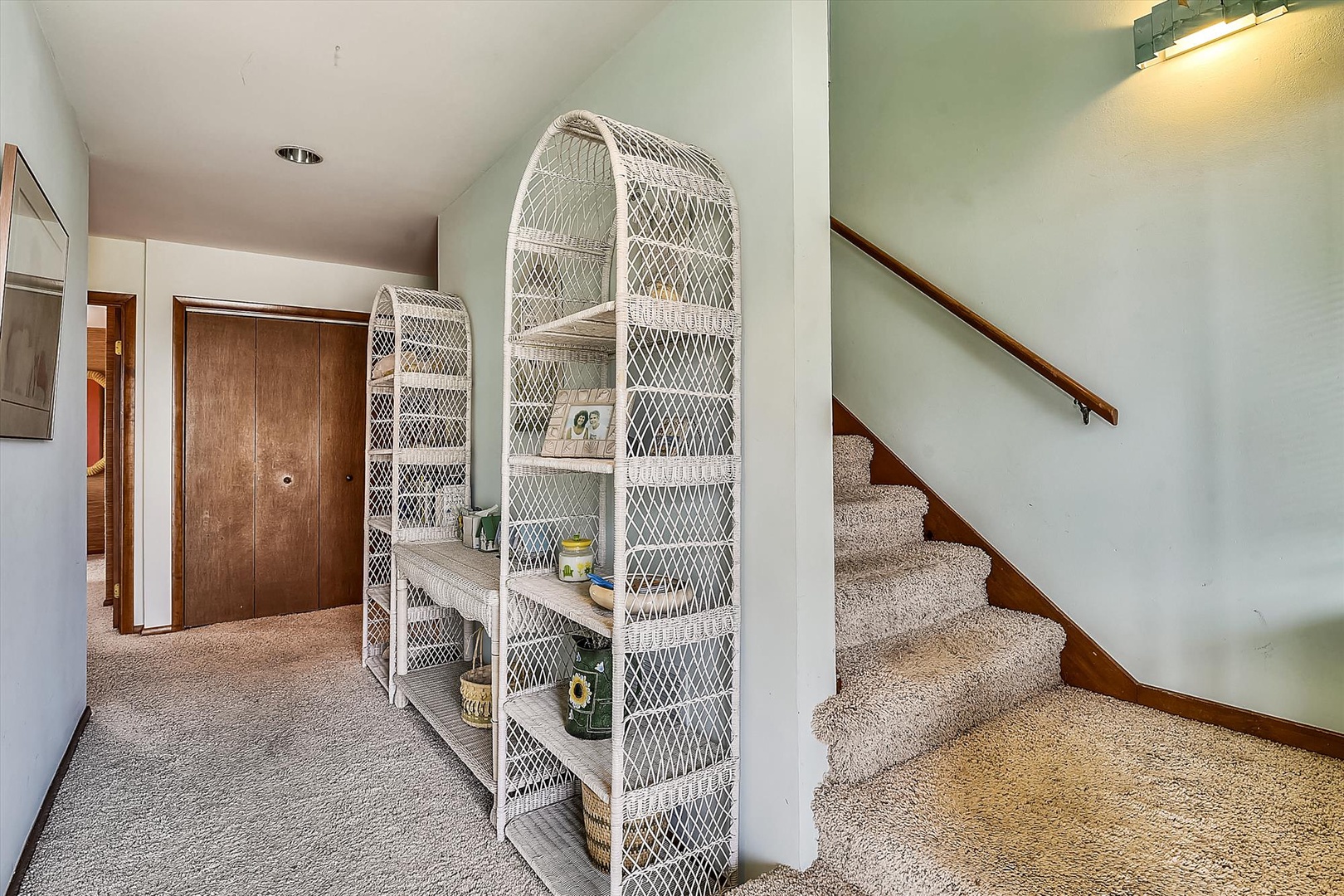 Your entry welcomes you with vaulted ceilings and coastal charm, featuring wicker shelving stocked with essentials and a staircase leading to private retreats above.