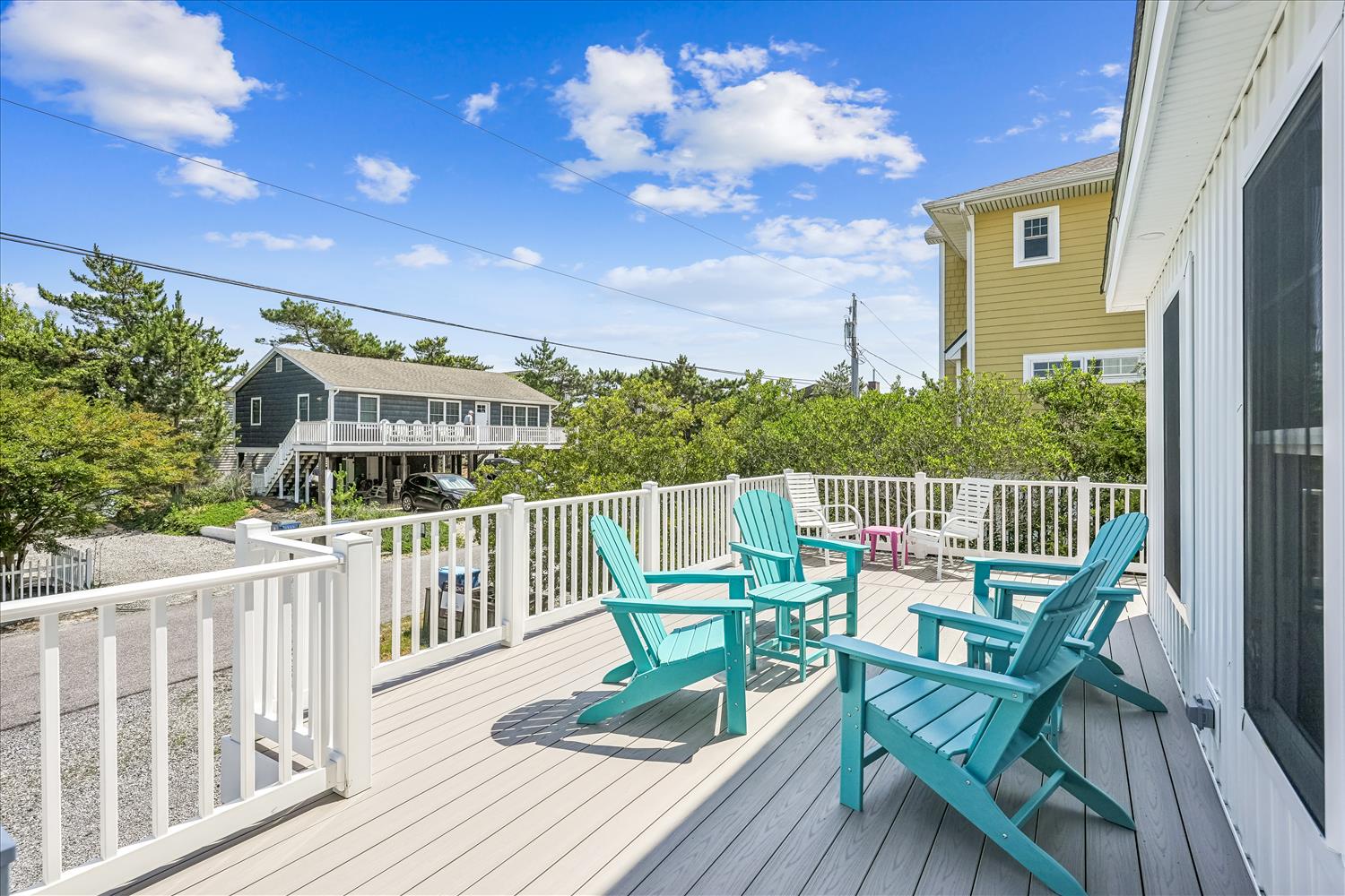 Relax on your private deck with bright turquoise chairs—perfect for morning coffee or evening cocktails while soaking in the neighborhood charm and coastal breezes.