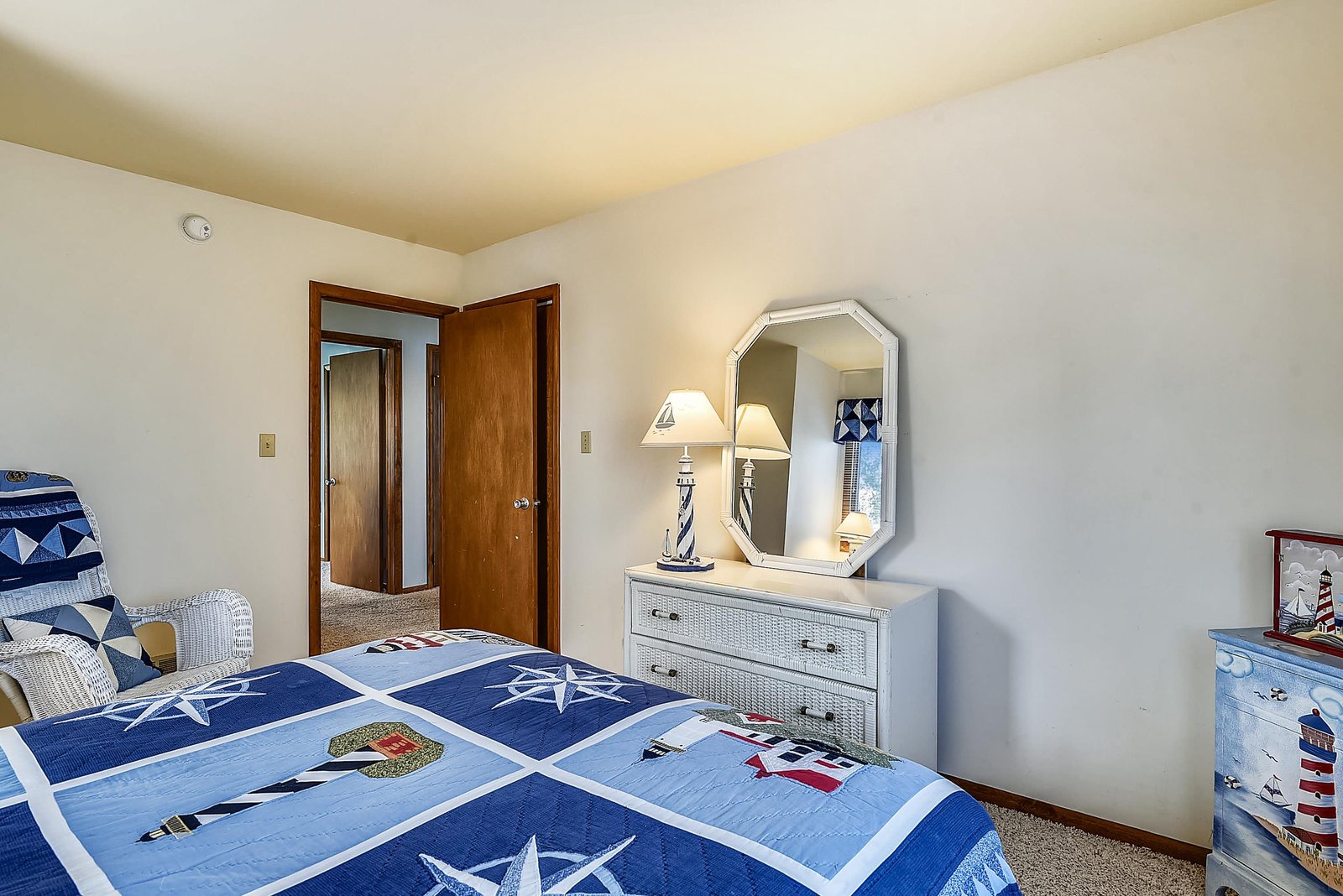 Settle into your cozy retreat featuring nautical-inspired décor and classic cottage charm. The comfortable bed invites restful nights, while warm wood tones and thoughtful lighting create a welcoming atmosphere.