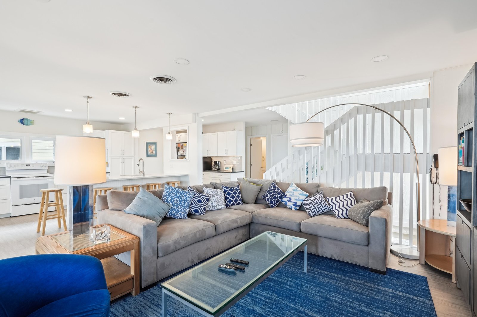 Settle into this bright coastal retreat with its plush sectional, cheerful blue accents, and open flow connecting you to the full kitchen—perfectly set up for effortless beach-town living.