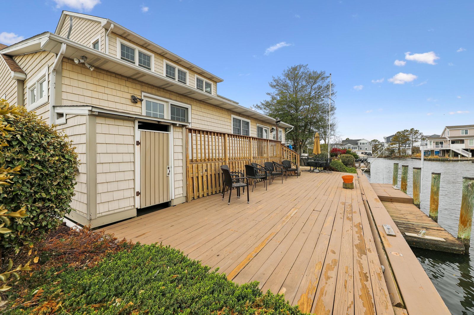 A spacious waterfront deck extends from the property, offering direct access to your private boat dock and serene water views under open skies.