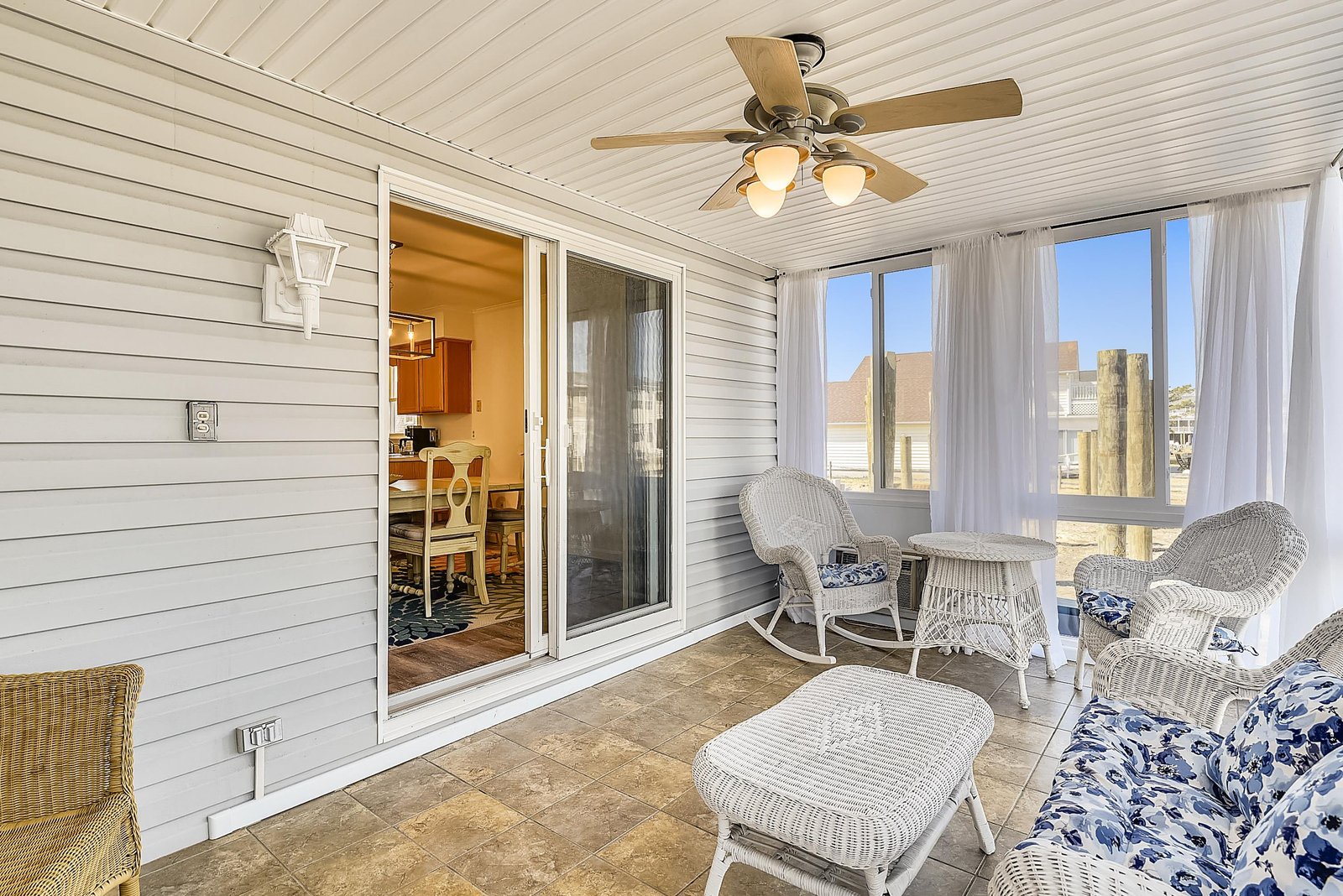Your private screened porch offers coastal comfort with wicker seating and soft breezes, perfect for morning coffee or evening relaxation with peaceful sounds of the shore.