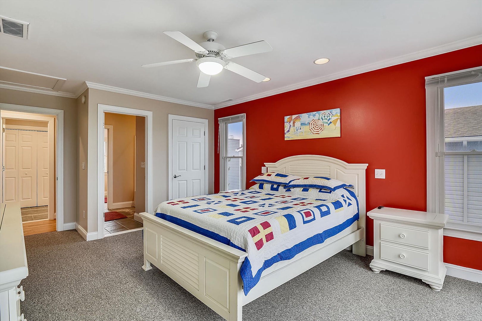 Sink into a cozy queen bed beneath a ceiling fan, with vibrant beach-themed decor and a private ensuite entrance making this your cheerful coastal retreat.