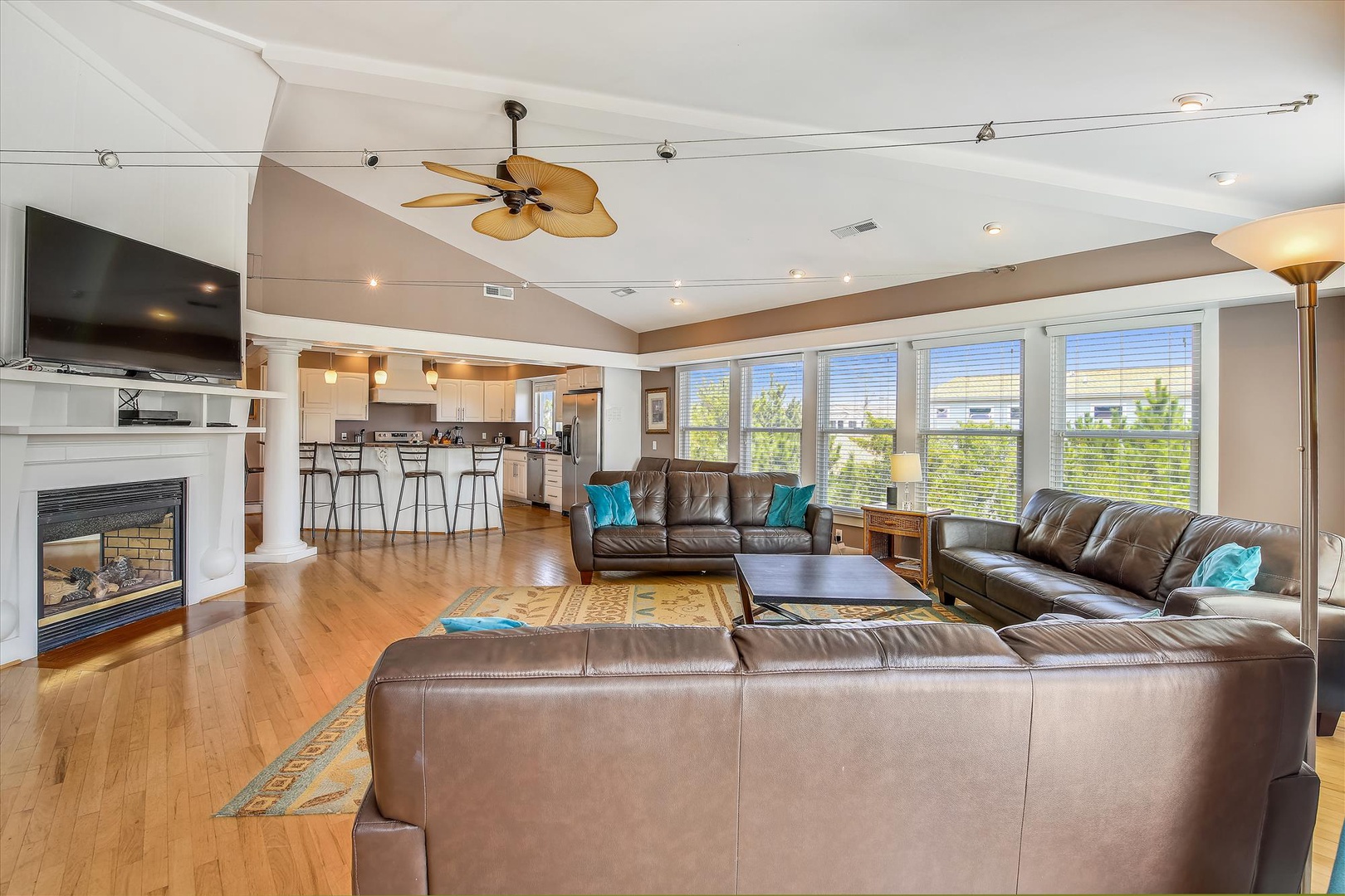 Sink into plush leather sofas in your open-concept living space, where natural light pours through expansive windows and a cozy fireplace awaits your evening gatherings.