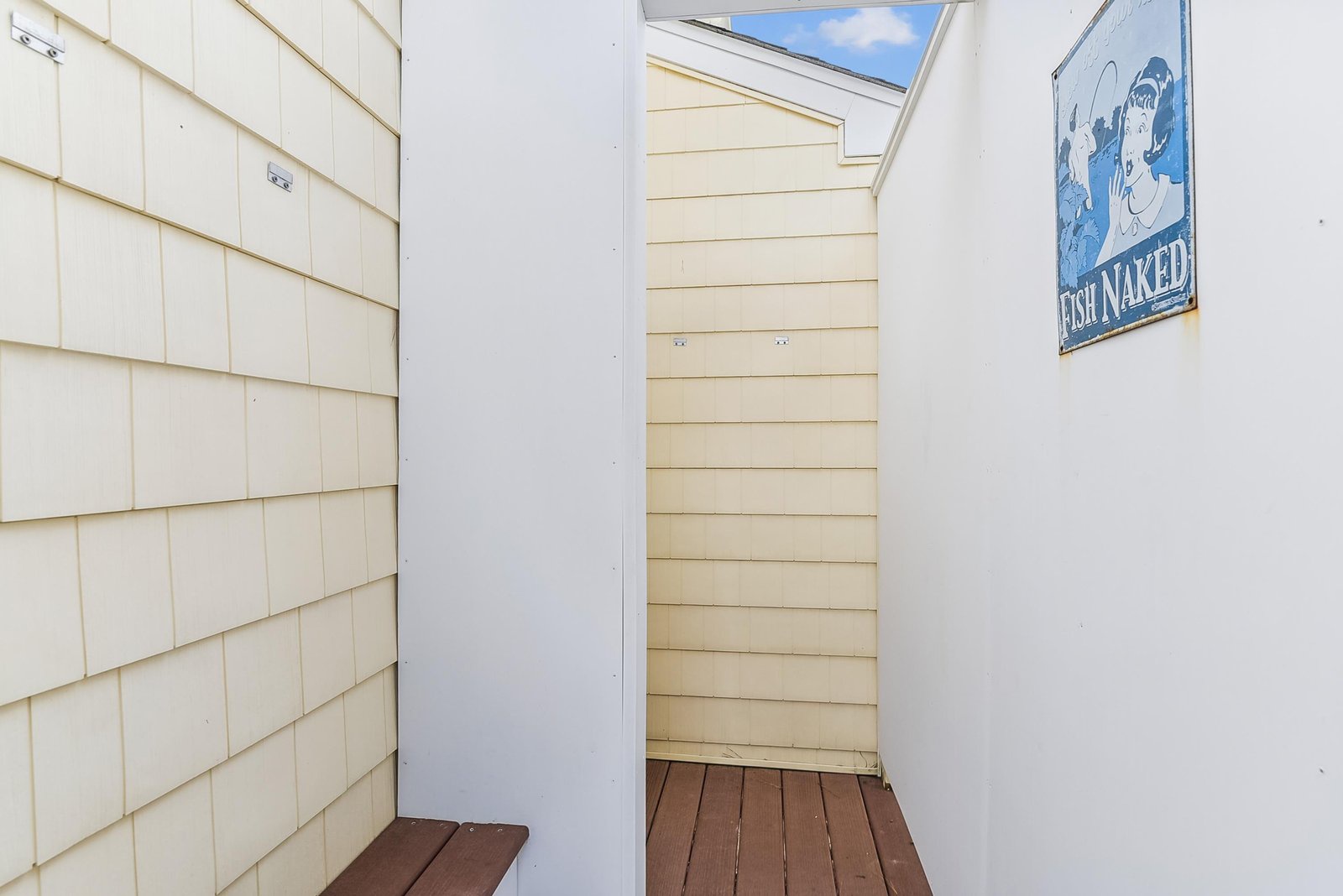 The property features a private outdoor shower area—perfect for rinsing off after a day at the beach. A charming beachy sign adds coastal character, and you'll love stepping out under the open sky.