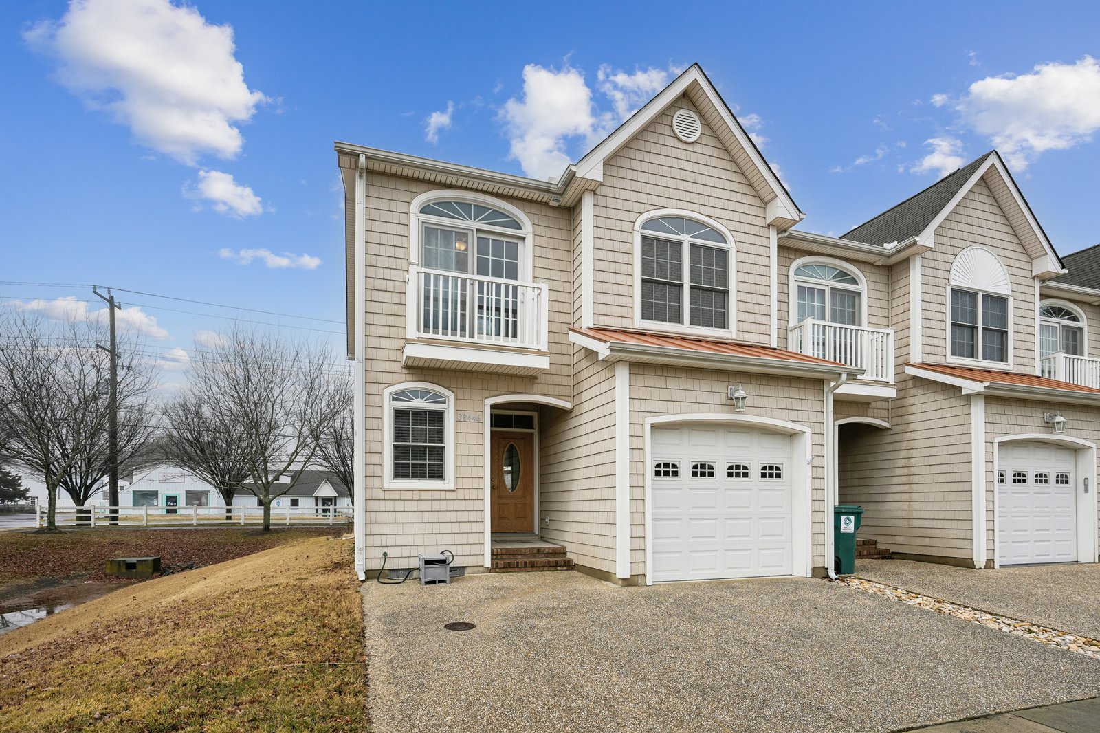 Modern coastal townhome with private garage and balconies in a peaceful residential setting.