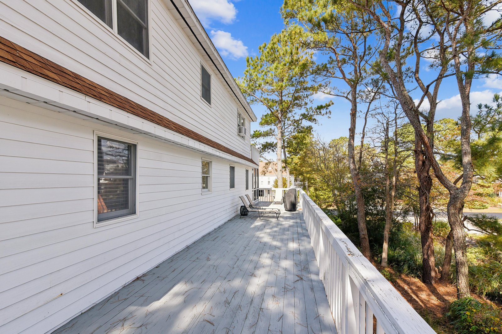 This spacious wraparound deck offers a peaceful retreat with serene views of towering pines and natural landscape, perfect for morning coffee or evening relaxation in your private outdoor space.