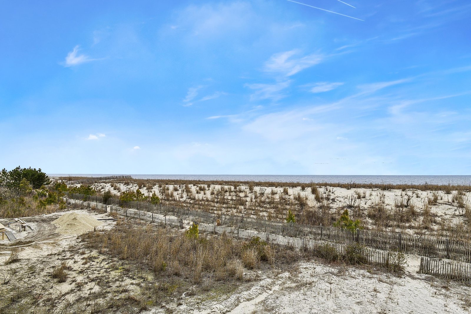 Scenic coastal landscape with sandy dunes, natural vegetation, and ocean views, part of the property's surrounding area.
