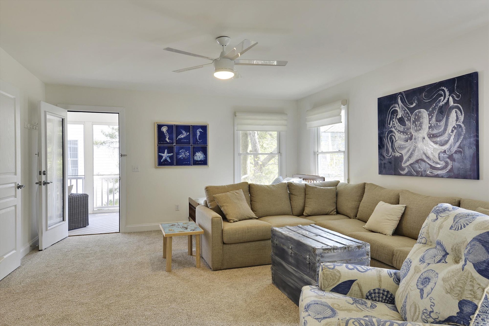 Sink into the cozy sectional in your bright living room, where coastal artwork and natural light create a breezy, relaxed vibe perfect for unwinding after a beach day.