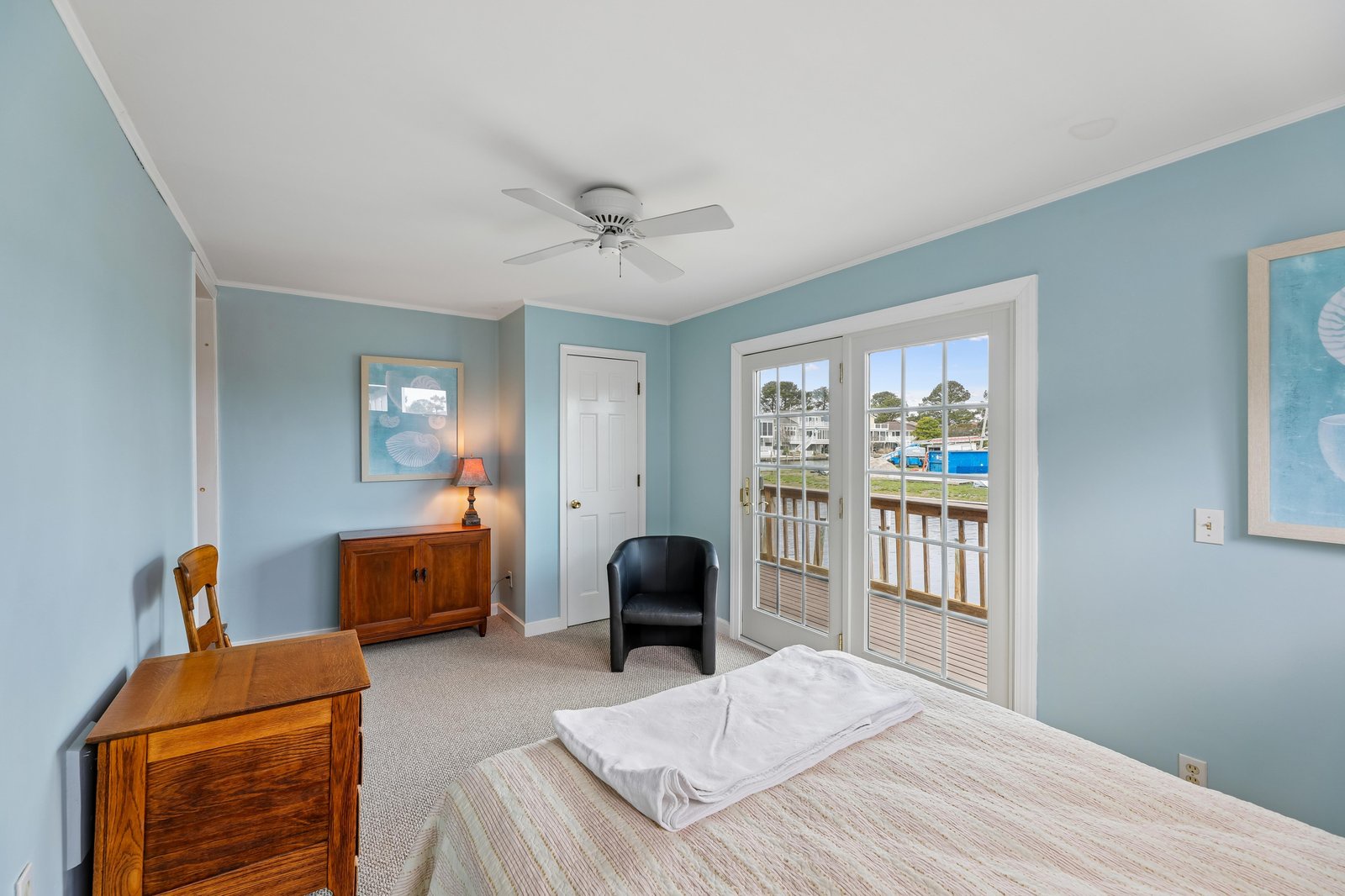 Drift off to sleep in this tranquil bedroom with soothing coastal tones and French doors opening to your private waterfront view. Crisp linens and soft lighting create the perfect retreat.
