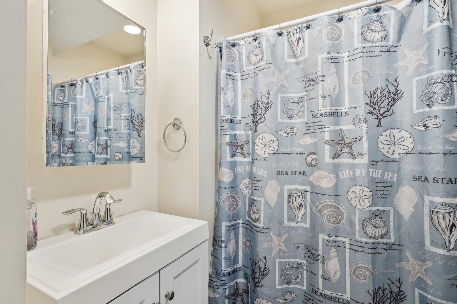 Step into your bright, coastal-themed bathroom with a charming seaside-inspired shower curtain and fresh, clean finishes—your perfect refreshing retreat.