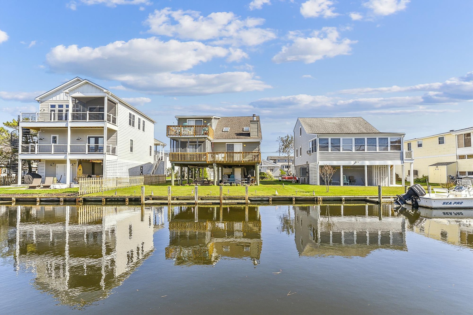 Waterfront vacation homes with private docks on a serene canal, offering direct water access and coastal charm in a peaceful neighborhood setting.