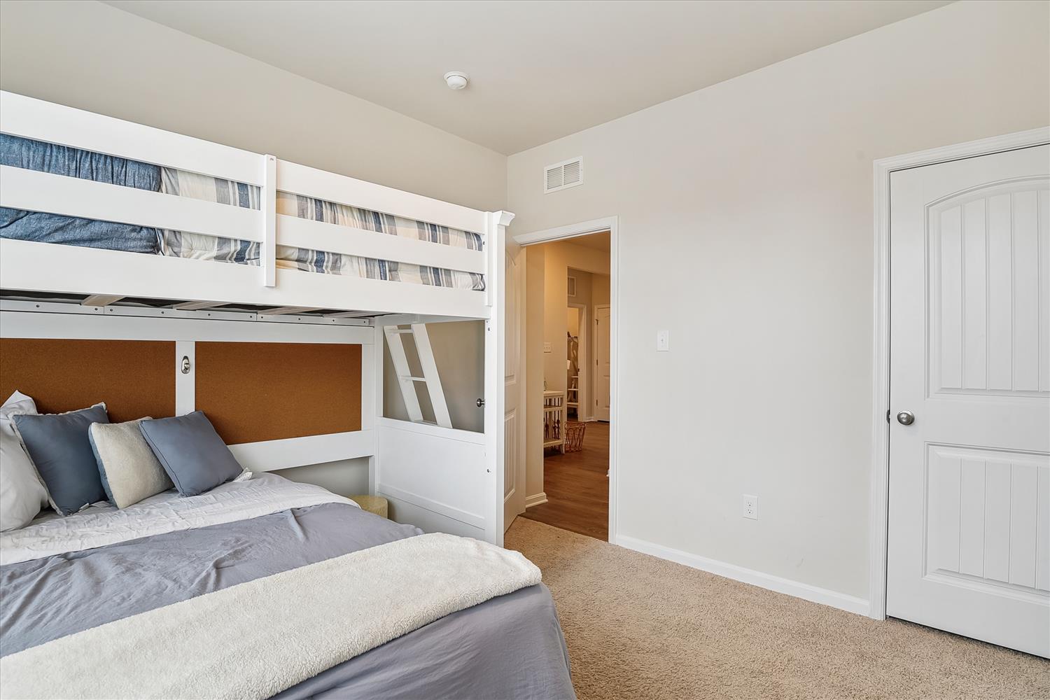 Your comfortable bedroom with a bunk bed above, offering flexible sleeping arrangements. Soft carpeting underfoot and ample closet space make it feel like home during your stay.