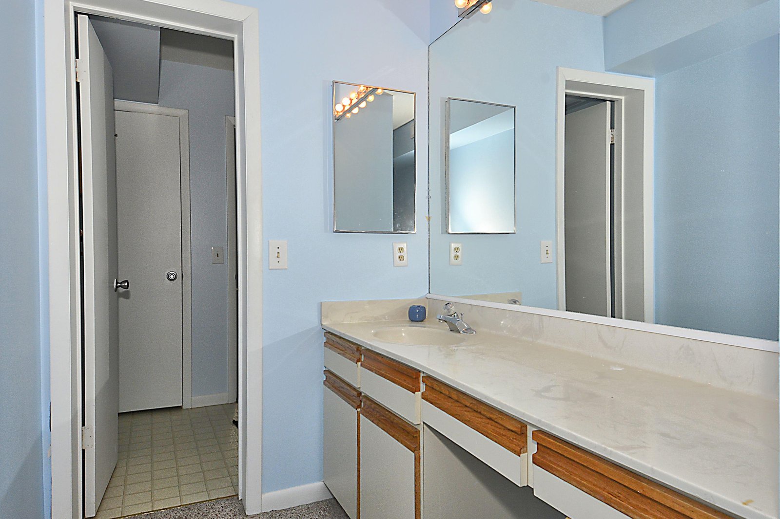 Step into your private bathroom, where soft blue walls and warm lighting create a calming retreat. The spacious double-sink vanity gives you plenty of room to get ready for your next adventure.