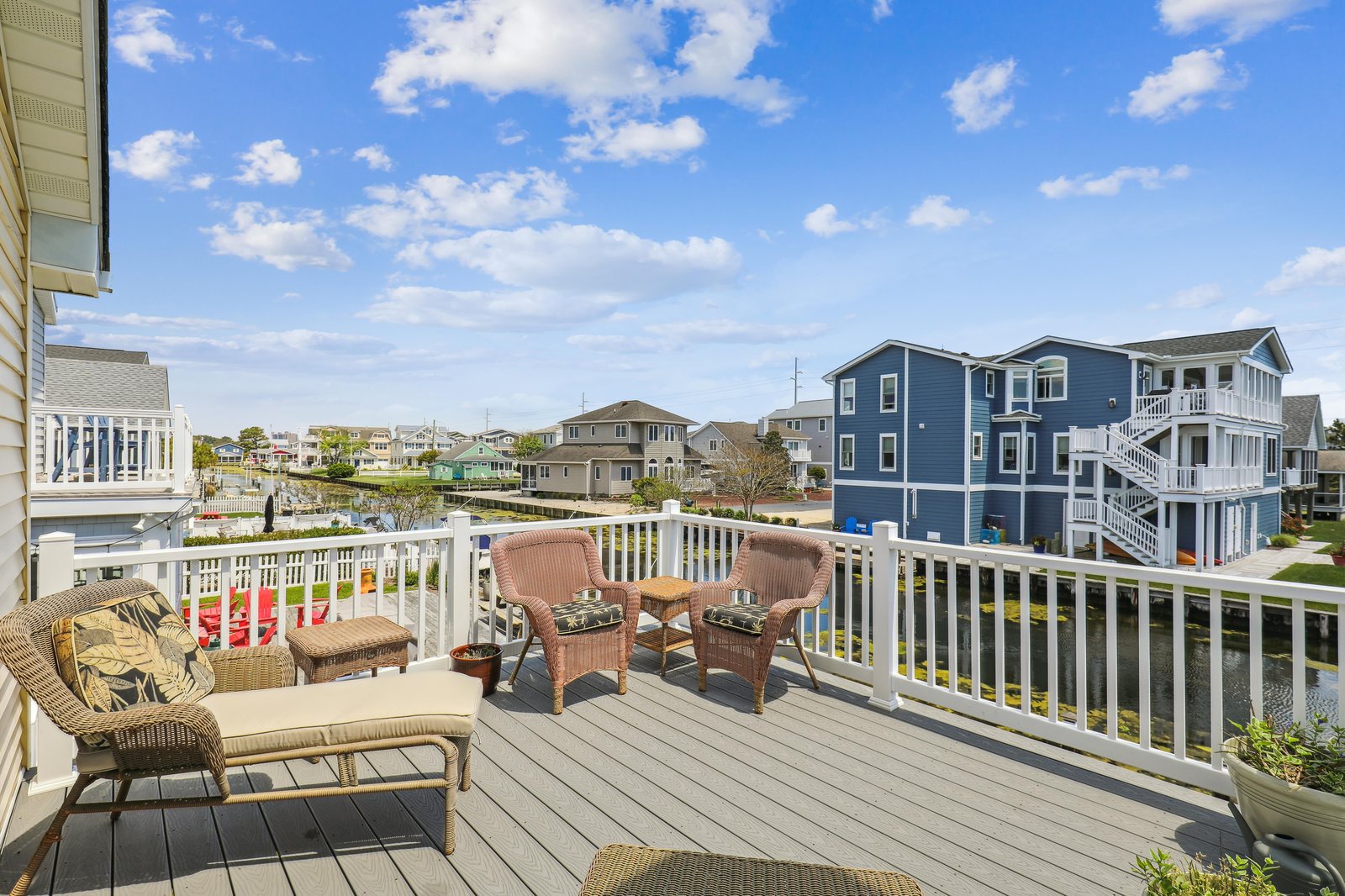 A waterfront community marks your arrival, with charming coastal architecture lining peaceful canals beneath open blue skies.